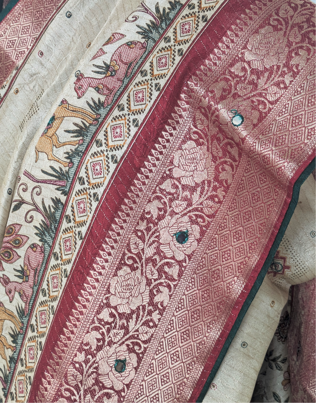 Beige silk saree with intricate deer motifs, maroon zari floral border, and traditional woven detailing