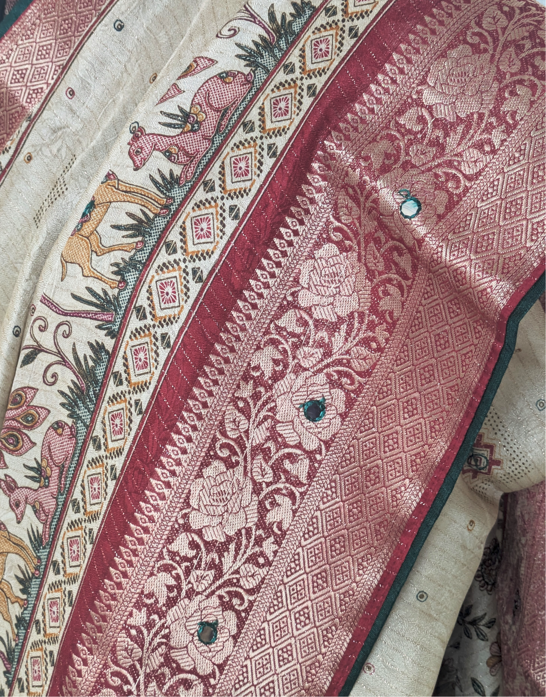 Beige silk saree with intricate deer motifs, maroon zari floral border, and traditional woven detailing